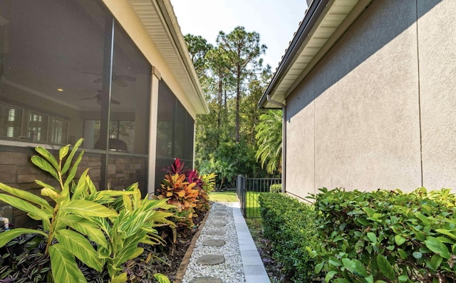 view of property exterior featuring a sunroom and ceiling fan