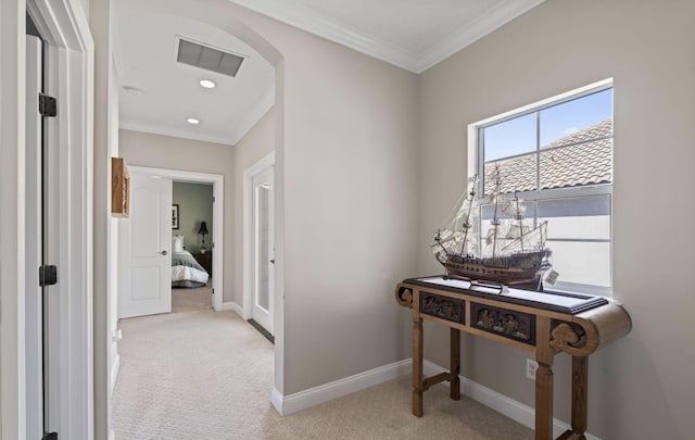 hall with ornamental molding and light carpet