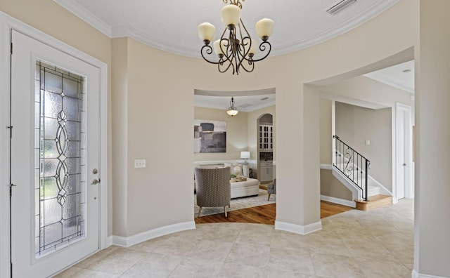 entrance foyer featuring light hardwood / wood-style flooring, ornamental molding, and a notable chandelier