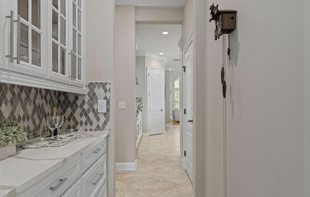 hallway with crown molding and light tile patterned flooring