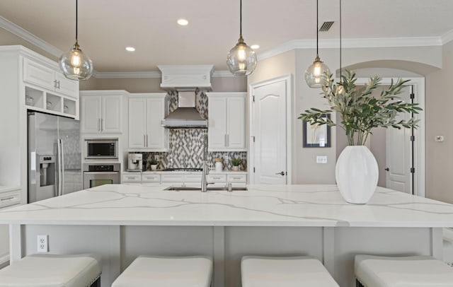 kitchen with a kitchen bar, stainless steel appliances, and hanging light fixtures