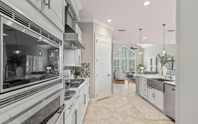 kitchen featuring pendant lighting, decorative backsplash, white cabinetry, and stainless steel appliances