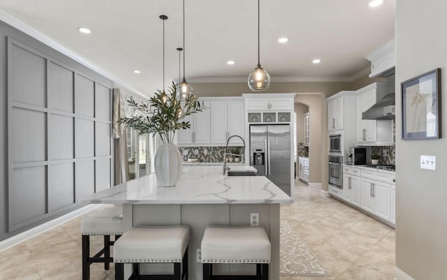 kitchen with a spacious island, white cabinetry, pendant lighting, and stainless steel appliances