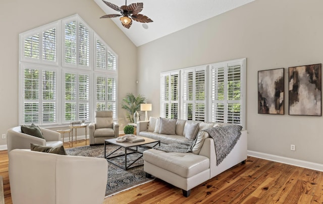 living room with hardwood / wood-style floors, ceiling fan, a healthy amount of sunlight, and high vaulted ceiling