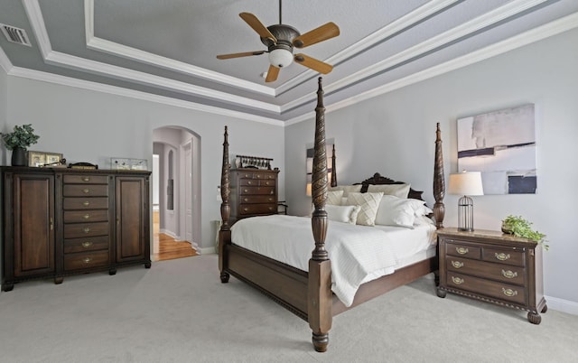 bedroom featuring light carpet, a raised ceiling, and ceiling fan