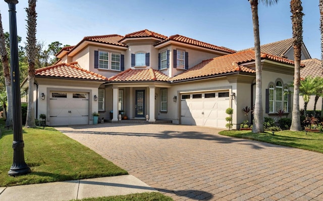 mediterranean / spanish-style home featuring a garage and a front lawn