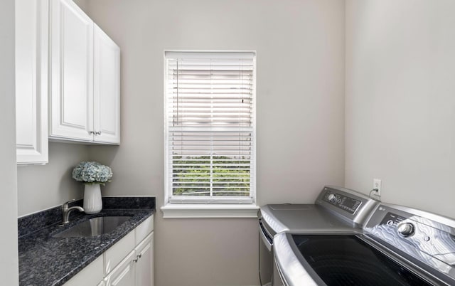 washroom featuring washing machine and clothes dryer, cabinets, and sink