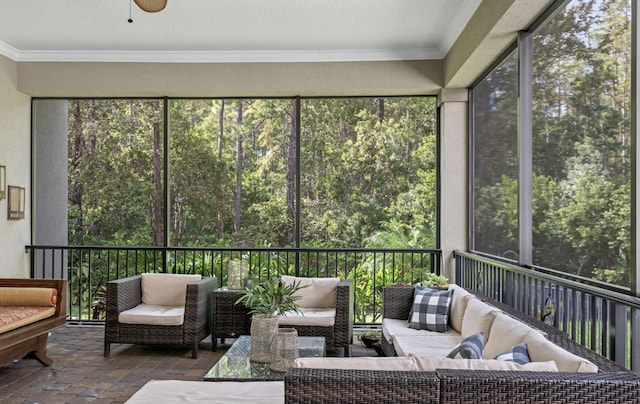 sunroom featuring ceiling fan and plenty of natural light