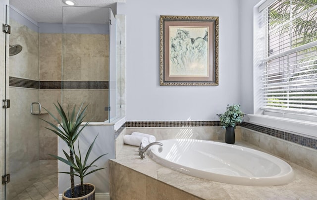 bathroom featuring a textured ceiling and shower with separate bathtub