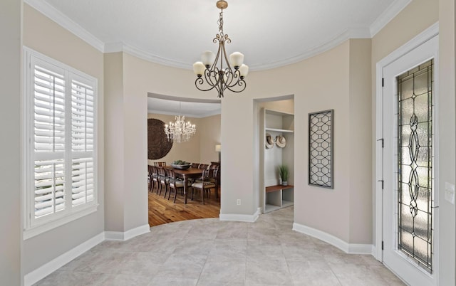 interior space with a notable chandelier, light hardwood / wood-style floors, and ornamental molding