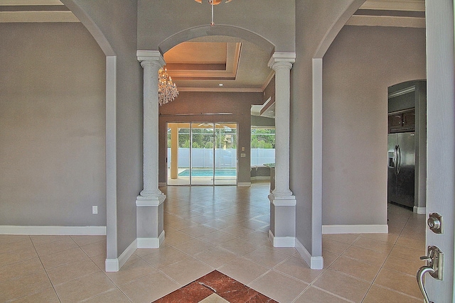 30 Fortress Pl, Palm Coast, FL 32137 - entryway featuring a raised ceiling, arched walkways, decorative columns, light tile patterned floors, and baseboards