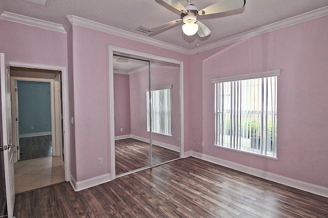 30 Fortress Pl, Palm Coast, FL 32137 - unfurnished bedroom with dark wood finished floors, a closet, baseboards, crown molding, and ceiling fan