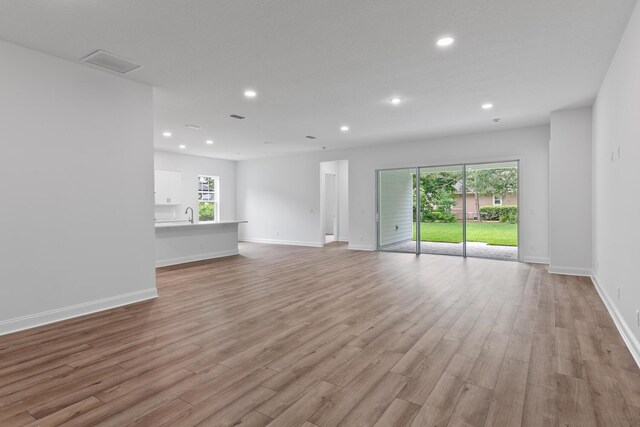 5013 Clayton Ct, Saint Augustine, FL 32092 - unfurnished living room featuring visible vents, light wood-style flooring, baseboards, and recessed lighting