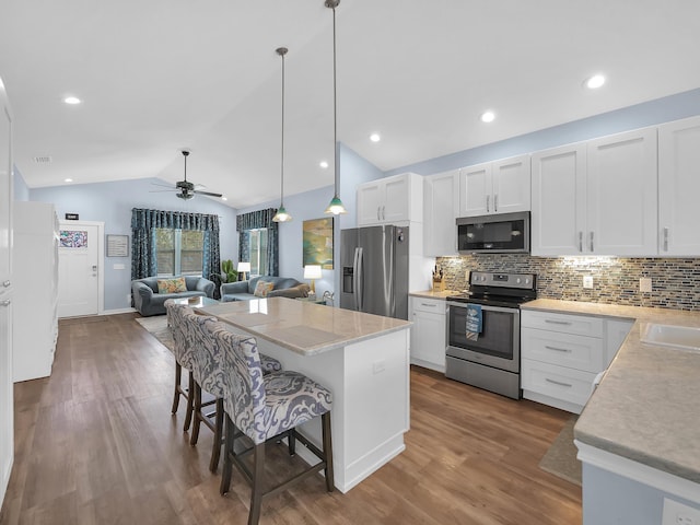 519 Arricola Ave, Saint Augustine, FL 32080 - kitchen with a ceiling fan, vaulted ceiling, wood finished floors, light countertops, and stainless steel appliances