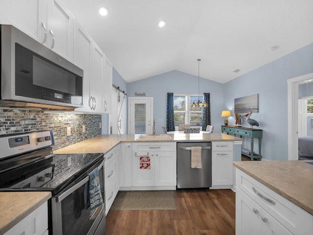 519 Arricola Ave, Saint Augustine, FL 32080 - kitchen with white cabinets, vaulted ceiling, a sink, stainless steel appliances, and backsplash