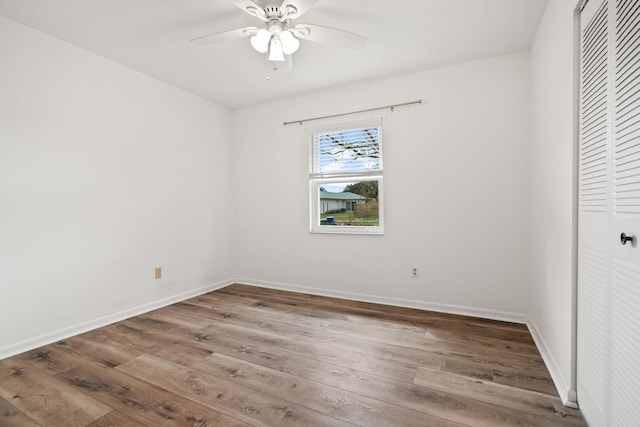 unfurnished bedroom featuring a closet, baseboards, and wood finished floors