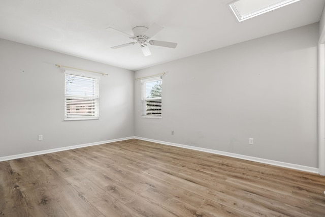 empty room featuring wood finished floors, a ceiling fan, and baseboards