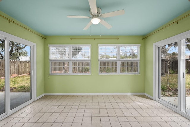 unfurnished sunroom featuring ceiling fan and a healthy amount of sunlight