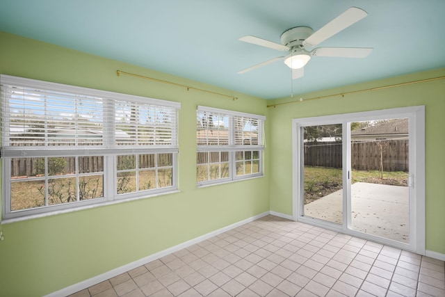 unfurnished sunroom featuring a ceiling fan