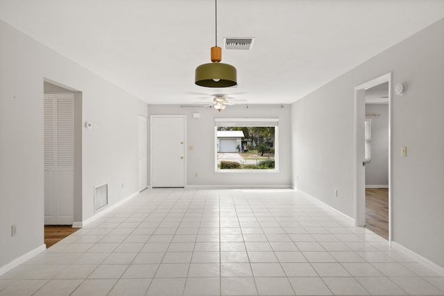 unfurnished living room with light tile patterned floors, baseboards, visible vents, and a ceiling fan