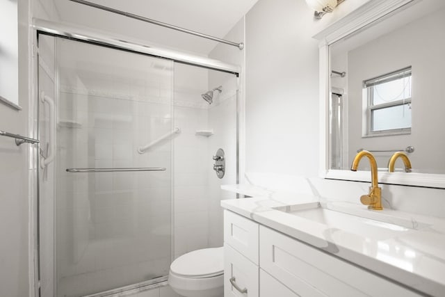 bathroom with toilet, a stall shower, and vanity