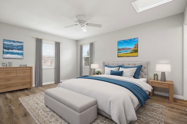 bedroom featuring ceiling fan, baseboards, and wood finished floors