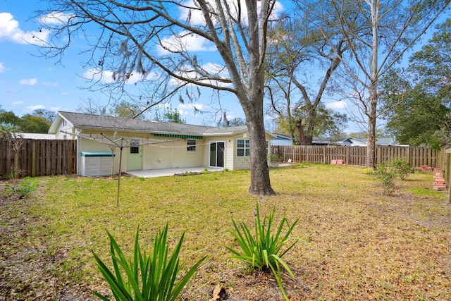 view of yard featuring a patio area, a fenced backyard, and an attached garage