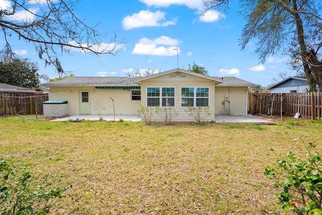 rear view of house featuring a patio area, a lawn, and a fenced backyard