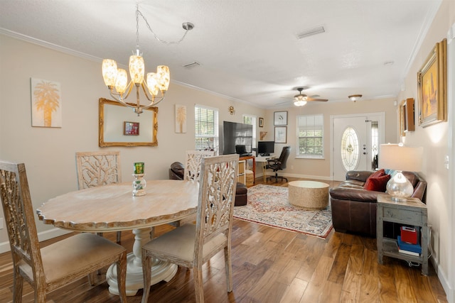 dining room featuring hardwood / wood-style floors, ceiling fan with notable chandelier, and ornamental molding