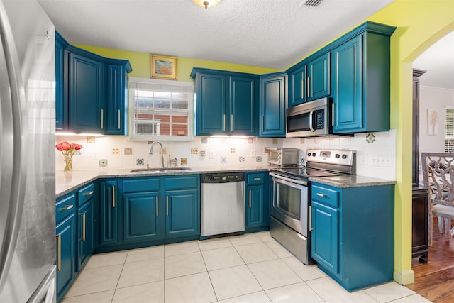 162 Martin Luther King Ave, Saint Augustine, FL 32084 - kitchen with stainless steel appliances, decorative backsplash, arched walkways, dark stone countertops, and a textured ceiling