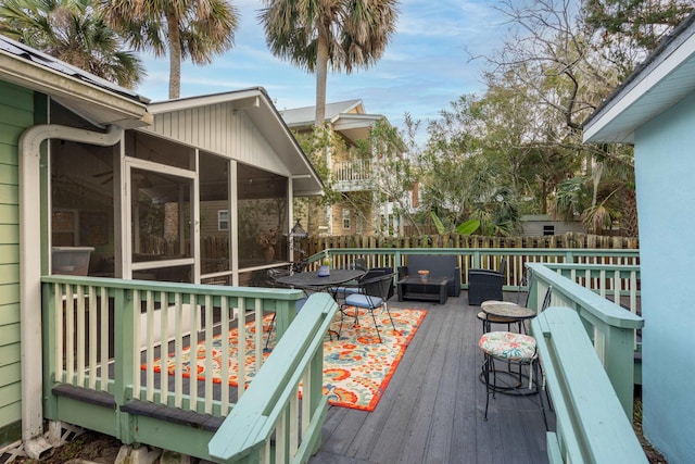 wooden deck featuring a sunroom and an outdoor living space