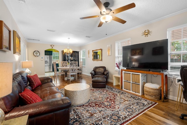 living room featuring a textured ceiling, hardwood / wood-style floors, ceiling fan with notable chandelier, and ornamental molding