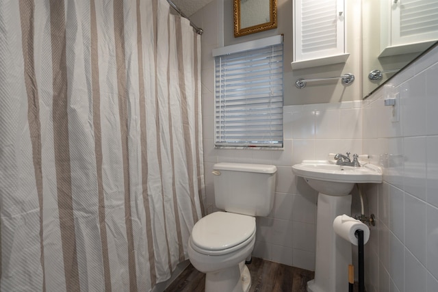 bathroom featuring hardwood / wood-style floors, sink, toilet, tile walls, and walk in shower