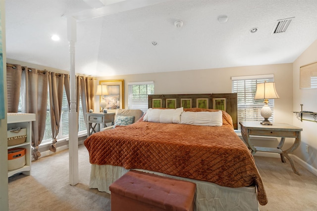 bedroom with a textured ceiling, vaulted ceiling, light carpet, and multiple windows