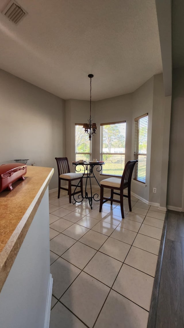 dining room featuring healthy amount of natural light, a chandelier, and baseboards