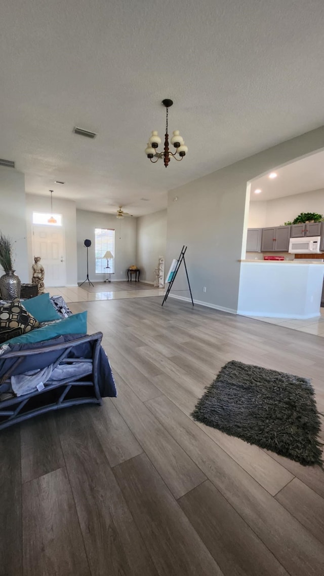 workout room with a chandelier, light wood-style floors, baseboards, and recessed lighting