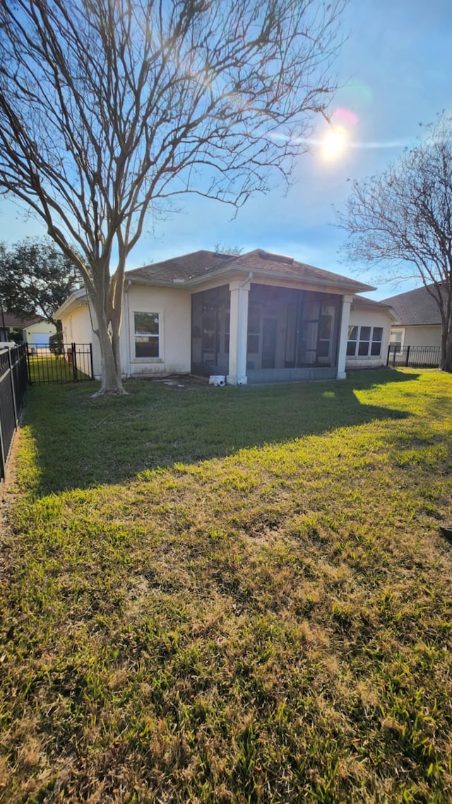 back of property with a sunroom and stucco siding