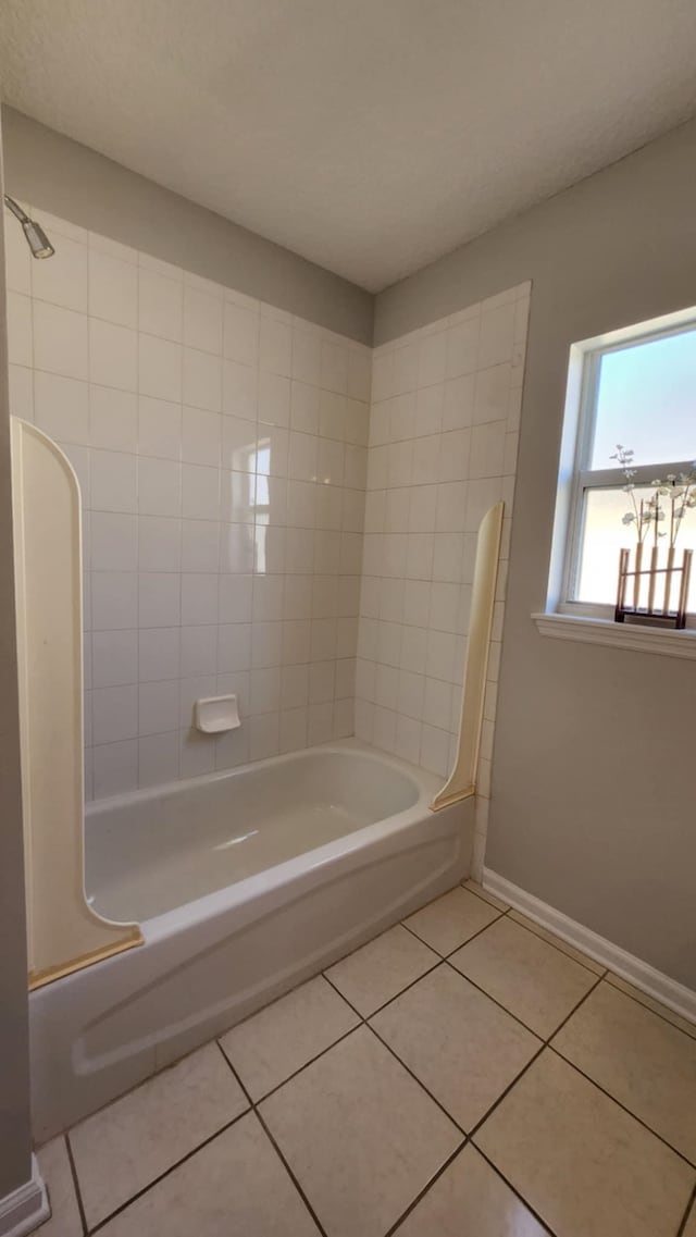 bathroom featuring tile patterned floors, baseboards, and bathing tub / shower combination