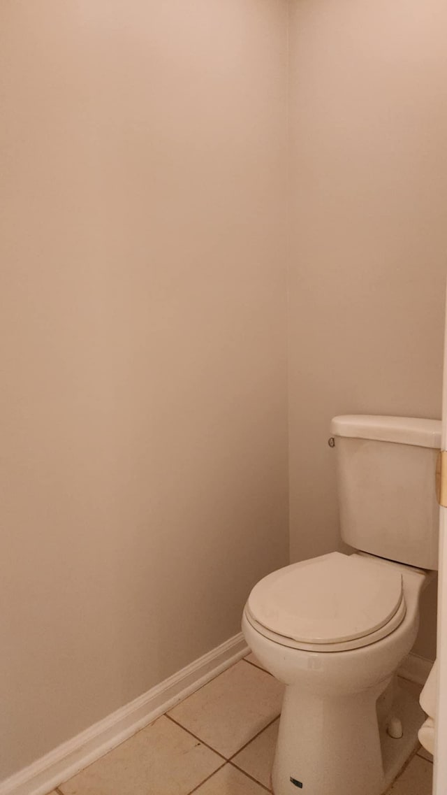 bathroom with tile patterned floors, toilet, and baseboards