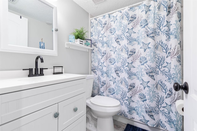 bathroom with vanity, toilet, and a textured ceiling