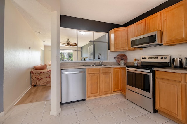 9 Kings Colony Ct Unit 9, Palm Coast, FL 32137 - kitchen with appliances with stainless steel finishes, a sink, light countertops, a ceiling fan, and light tile patterned floors