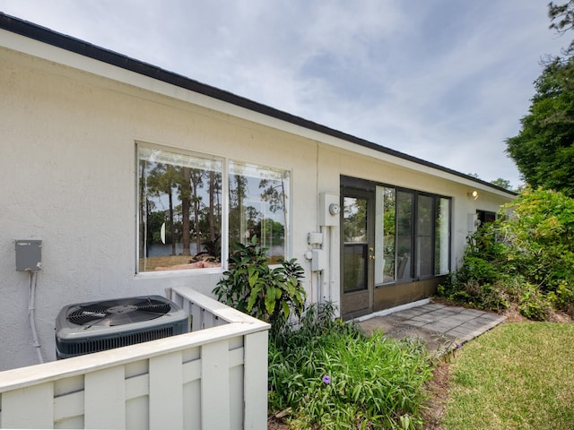 9 Kings Colony Ct Unit 9, Palm Coast, FL 32137 - view of exterior entry with stucco siding and central AC