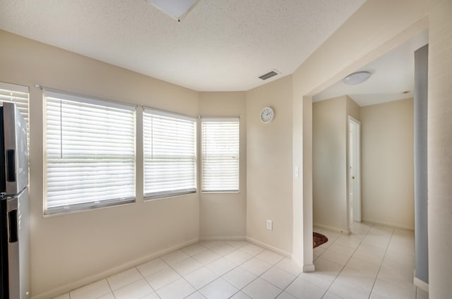9 Kings Colony Ct Unit 9, Palm Coast, FL 32137 - empty room with light tile patterned flooring, baseboards, and a textured ceiling