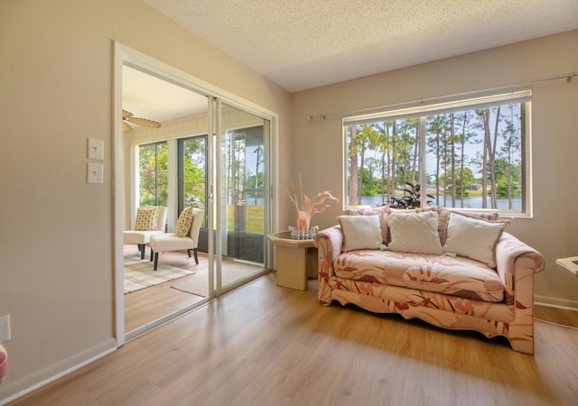 9 Kings Colony Ct Unit 9, Palm Coast, FL 32137 - sitting room featuring wood finished floors, plenty of natural light, a textured ceiling, and a water view