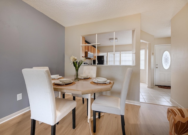 9 Kings Colony Ct Unit 9, Palm Coast, FL 32137 - dining space featuring healthy amount of natural light, light wood-style flooring, baseboards, and a textured ceiling