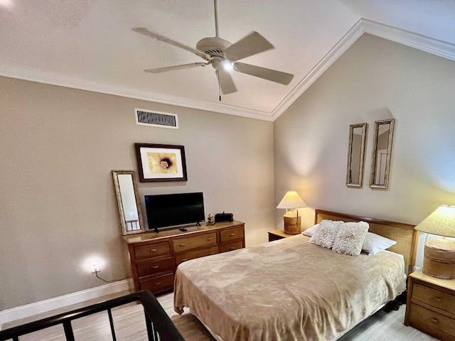 bedroom featuring wood finished floors, visible vents, baseboards, vaulted ceiling, and crown molding