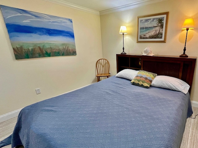 bedroom featuring crown molding, baseboards, and wood finished floors