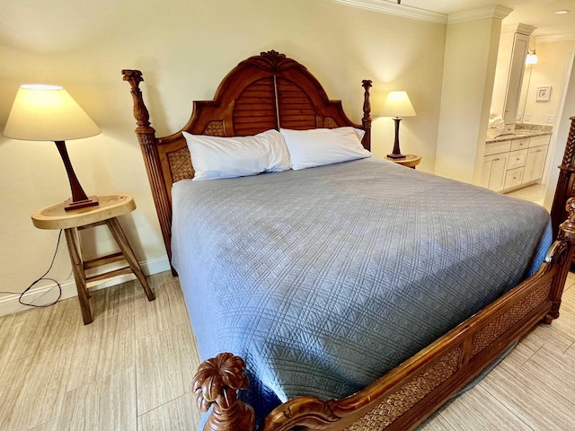 bedroom with connected bathroom, baseboards, and crown molding