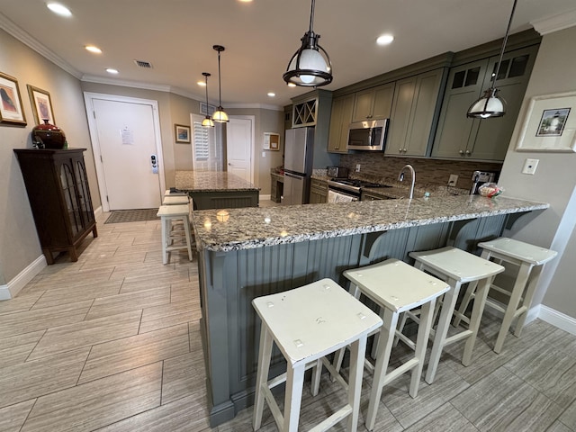 kitchen with stainless steel appliances, hanging light fixtures, a peninsula, and light stone counters