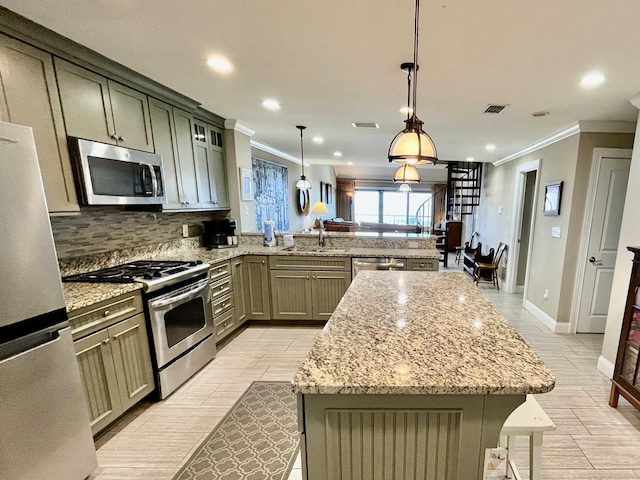 kitchen with a breakfast bar area, a center island, hanging light fixtures, stainless steel appliances, and a sink